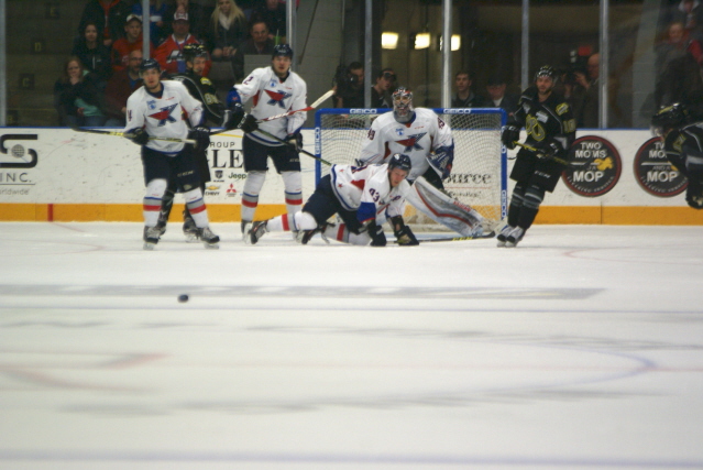K-Wing players watch as the puck travels down the ice heading for the empty net at the other end.